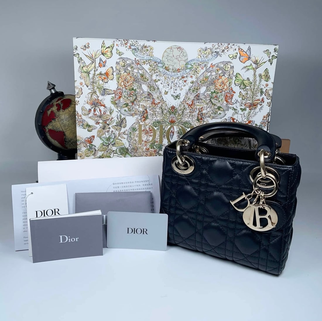 DIOR LADY DIOR MINI HANDBAG: DIOR LADY DIOR MINI HANDBAG DIOR, Lady Dior, Mini. A Cannage-quilted lambskin handbag with black leather handles and gold-tone letter charms. Dated late 2023 and accompanied by a complete set of