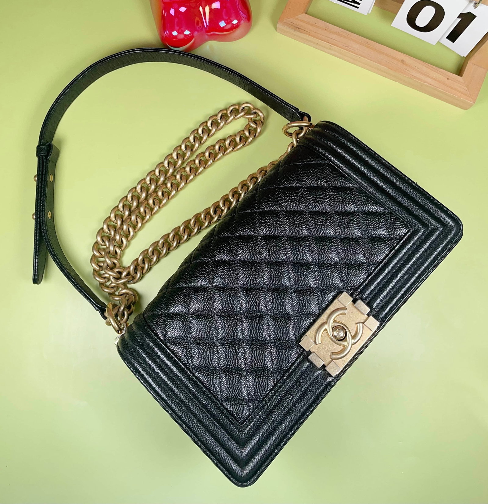 CHANEL BOY MEDIUM BLACK GRAINED CALFSKIN SHOULDER BAG: CHANEL BOY MEDIUM BLACK GRAINED CALFSKIN SHOULDER BAG CHANEL, Boy, Medium. A black grained calfskin shoulder bag with diamond quilting and aged gold-tone hardware. Dimensions: 25 × 14 × 7 cm.