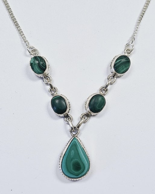 Sterling Silver Malachite Drop Necklace Necklace measures: Necklace measures 18" Weighs 18.0 grams This is a sterling silver necklace featuring five oval-shaped malachite stones in a symmetrical Y-shaped design. Four smaller stones are evenly spaced along the