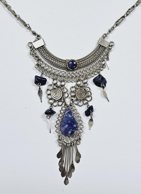 Silver Tone Agate Wirework Necklace Necklace weighs 16.7: Necklace weighs 16.7 Grams This is a silver tone statement necklace featuring intricate woven wirework and natural blue agate stones. The necklace has a bib-like design with a curved collar that sits