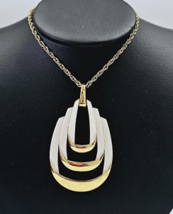 1960s Crown Trifari Gold Tone Enamel Necklace A stunning Vintage 1960's Crown Trifari gold tone: A stunning Vintage 1960's Crown Trifari gold tone white enamel necklace. The necklace measures 30 inches in total length and the pendant is 3 by 1.75 inches.