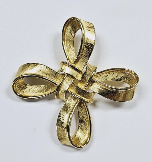 Vintage Crown Trifari Celtic Knot Bow Brooch The Trifari Celtic Knot Bow Brooch is a vintage gold: The Trifari Celtic Knot Bow Brooch is a vintage gold tone brooch that features a Celtic knot and a bow design.