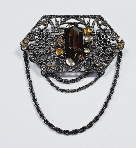 Lia Sophia Silver Tone Amber Rhinestone Brooch This Lia Sophia is a collectible dark tone metal: This Lia Sophia is a collectible dark tone metal brooch with Amber tones, crystals, and rhinestones. It is made of antique silver tone metal and features cut crystals.