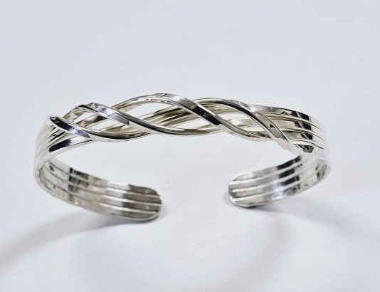 Sterling Silver Ofner & Co Cuff Bracelet Bracelet weighs 19.8: Bracelet weighs 19.8 Grams Silversmith Designer Rachel Strodtbeck This is a sterling silver cuff bracelet. It features four strands of silver that are twisted together in an overlapping pattern, creat