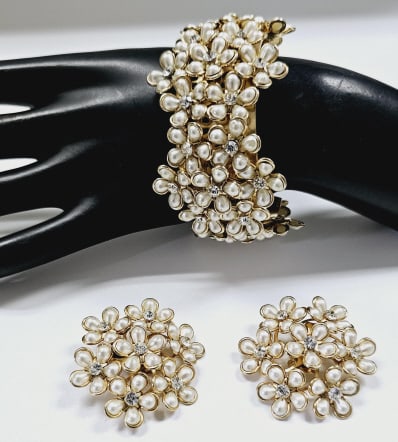Vintage Faux Pearl & Rhinestone Bracelet & Earring This is a vintage pearl and rhinestone bracelet: This is a vintage pearl and rhinestone bracelet and earrings set. The pieces are gold-tone metal and feature clusters of faux pearls arranged in flower shapes, with rhinestones in the centers. The bra