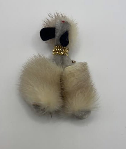 Vintage 1950s Genuine Mink Brooch Dog with Collar A vintage brooch in the shape of a poodle dog. The: A vintage brooch in the shape of a poodle dog. The dog is made of white fur, with black ears and a gold collar. It has a red gem for a nose and black beads for eyes.