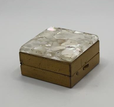 Confetti Lucite topped Pill Box Measures: Measures 1.5"x.75" ? Chip on Front Left Corner A small, square box with a brass base and a lid covered in mother-of-pearl pieces.