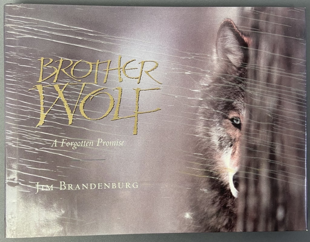 Brother Wolf Book by Jim Brandenburg Signed Hardcover book with color photographs of wolves and: Hardcover book with color photographs of wolves and other animals. Published by North Word Press, 1993. Signed in the title page by the author. Some staining on dust jacket.