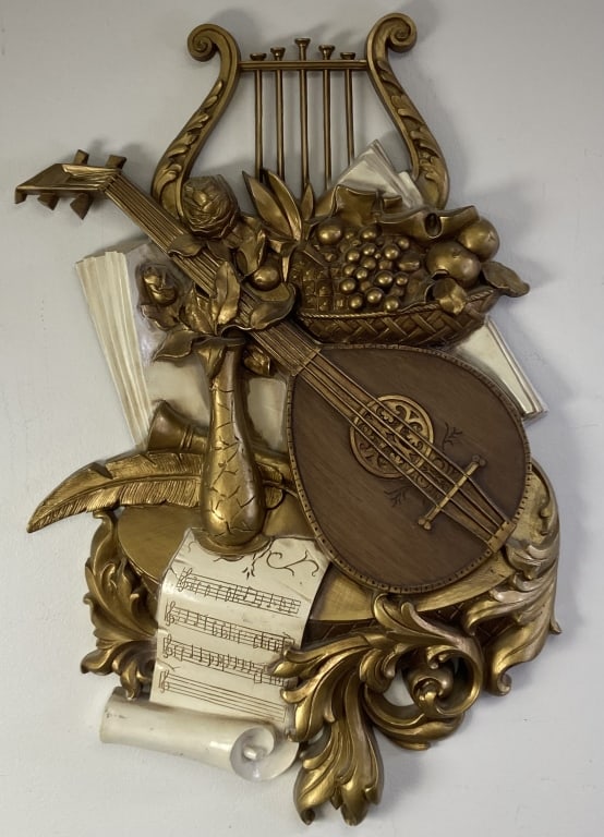 Mid Century Syroco Music Wall Hanging Hard plastic wall hanging featuring a harp, lyre, and sheet: Hard plastic wall hanging featuring a harp, lyre, and sheet music painted gold and white. Marked on the back 1971 Syroco Made in USA. Wall hanging is 30 1/4 inches tall, 20 inches wide.