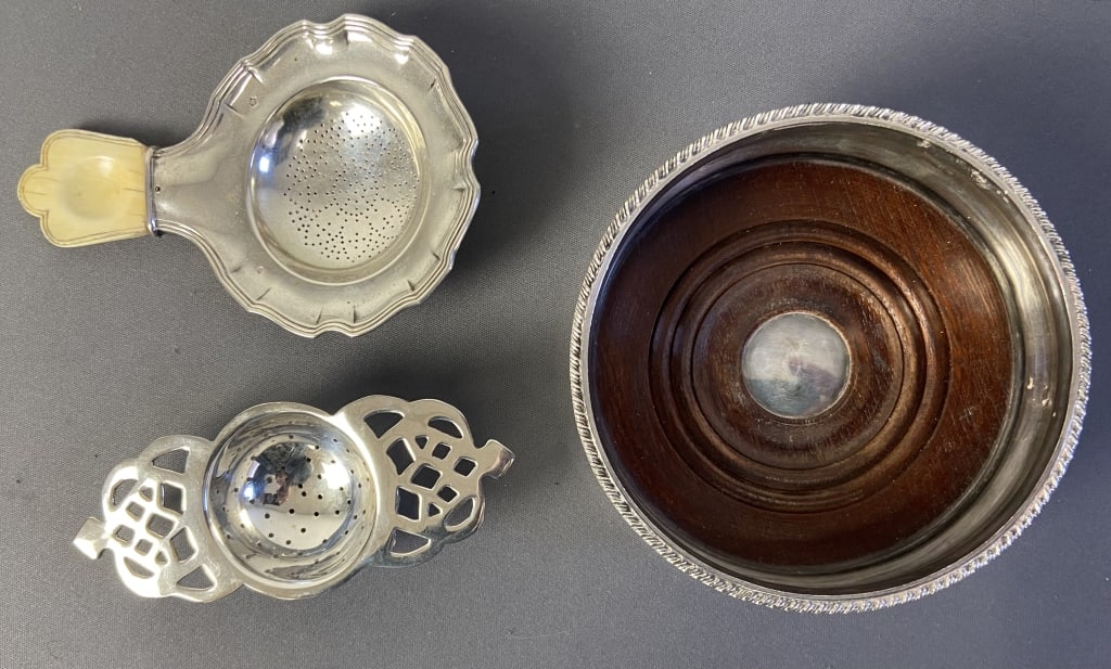 Silver Plate Tea Strainers & Wine Bottle Coaster Two vintage tea strainers, one with bone handle,: Two vintage tea strainers, one with bone handle, they are both unmarked. Wine bottle coaster, silver plate with wooden bottom, unmarked. Coaster is 5 1/4 inches in diameter and 1 3/4 inches tall.