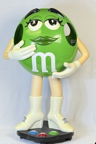 Green M&M Large Store Display 38 Inches Tall On wheels. Some scuffs and scratches. Slight yellowing