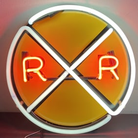 Neon Railroad Crossing Sign Circular yellow railroad crossing sign with red and white neon lights.