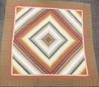 King Size Amish Made Quilt Trip Around the World pattern quilt in browns, greens, yellows, and reds.