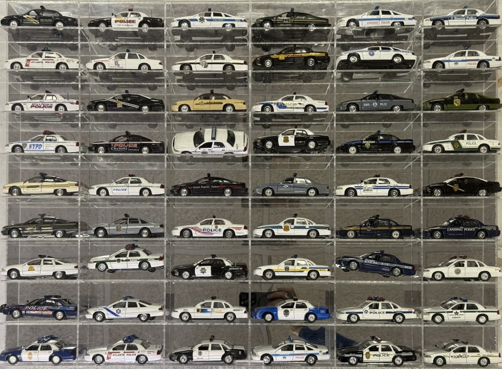 Diecast Police Cars Collection 1/43 Scale 54 cars in acrylic mirror backed case. 32.5 x 24 x 2.5: 54 cars in acrylic mirror backed case. 32.5 x 24 x 2.5 inches. Cars in good condition. Case is free from cracks.