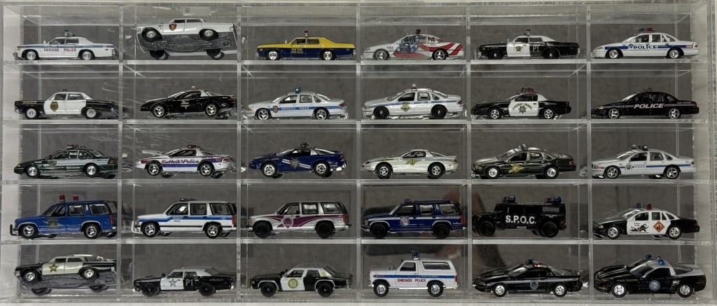Diecast Police Cars Collection 1/64 Scale 30 cars in acrylic mirror backed case. 16 x 11 x 2.5: 30 cars in acrylic mirror backed case. 16 x 11 x 2.5 inches. Cars in good condition. Case has cracks in bottom corners.