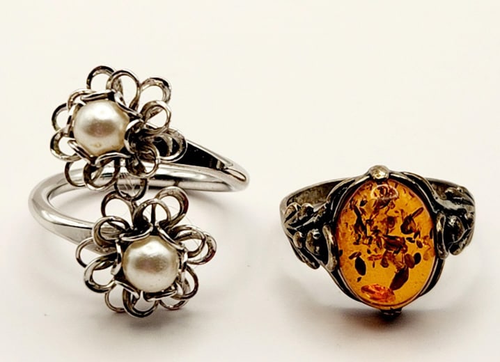 Amber Sterling & Emmons Silver Tone Floral Rings Amber (acid tested) sterling ring weighs 2.5: Amber (acid tested) sterling ring weighs 2.5 grams. Emmons floral ring is silver tone & beads. Lot weighs 5.6 grams.