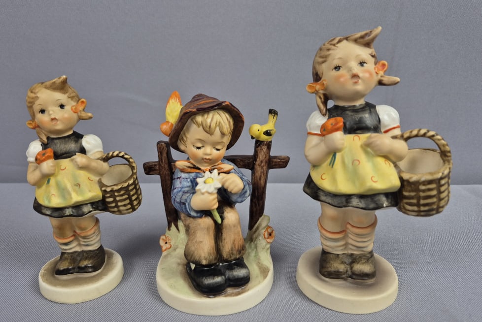 Goebel Hummel Figurines She Loves Me She Loves Me Not 174 & 2 Sister 98 Figurines: Not 174 & 2 Sister 98 Figurines She Loves Me measures 4.375 inches tall, TMK #6. Sister figurines measure 4.5 and 5 inches tall, TMK #3 and #4. Chips on dress and around base of Sister, all have crazi