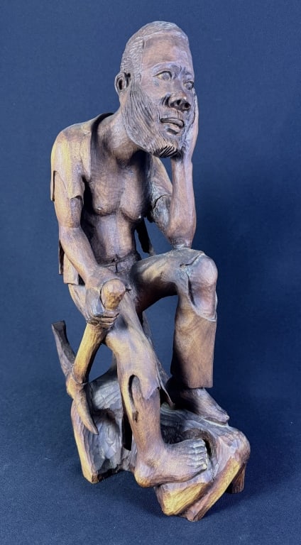 Carved Wooden African Statue Emile Jr Louis 20 inches tall. 11 inches deep, 5.5 inches wide. Some: 20 inches tall. 11 inches deep, 5.5 inches wide. Some repairs.