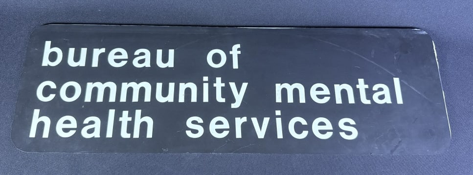 Bureau of Community Mental Health Services Sign Measures 23 x 7.25 inches. Scuffs and scratches: Measures 23 x 7.25 inches. Scuffs and scratches present over all. See photos for details.