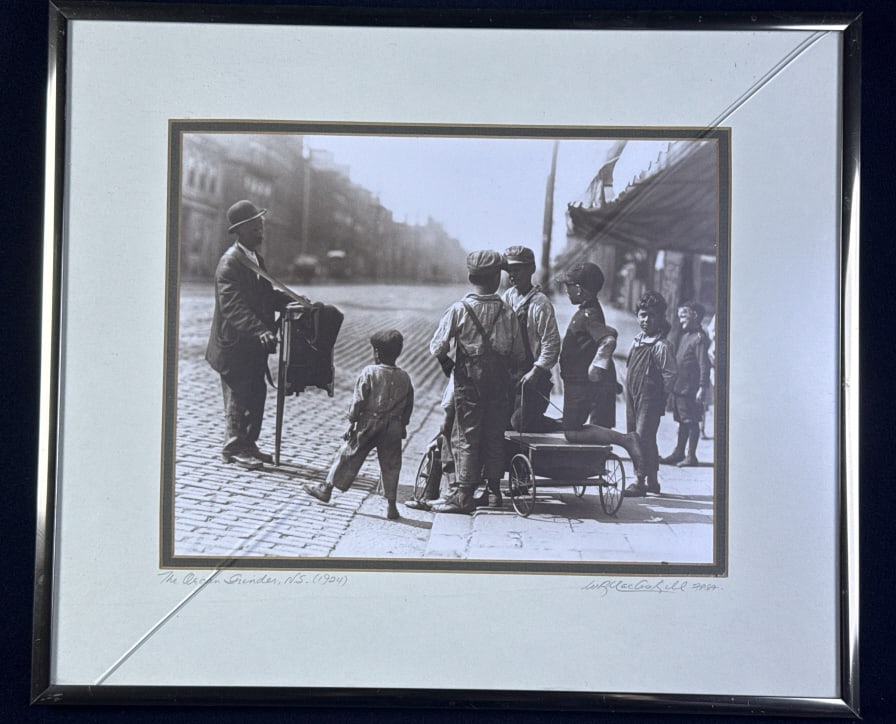 W.R. MacAskill Photograph The Organ Grinder Matted and framed (crack in glass) measuring 14.25 x: Matted and framed (crack in glass) measuring 14.25 x 12.25 x 1 inches.