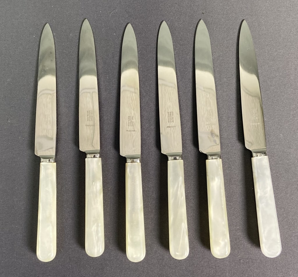 Sheffield Butter Knife Set with Box Set of six butter knives with white lucite handles and stainless: Set of six butter knives with white lucite handles and stainless steel blades. Marked Cox Ltp Sheffield England Stainless. Stain on lid of box.