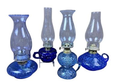 Antique Blue Glass Oil Lamps 4 measuring between 11 and 12 inches tall and 4 and 6 inches wide.
