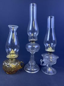 Antique Glass Oil Lamps Lot of 3 One Amber two clear. Tallest stands 19.5 inches tall and is missing