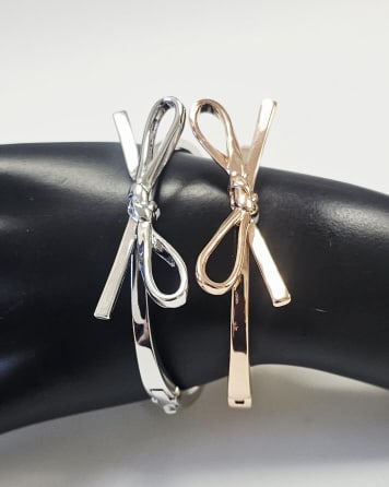 Pair of Kate Spade New York Skinny Bow Bangles A pair of Kate Spade bangles in silver tone and rose: A pair of Kate Spade bangles in silver tone and rose gold. Inner circumference 2.5 inchesFor the best shipping rates, please select "Self-Arranged." Once you've done this, you will automatically be ad