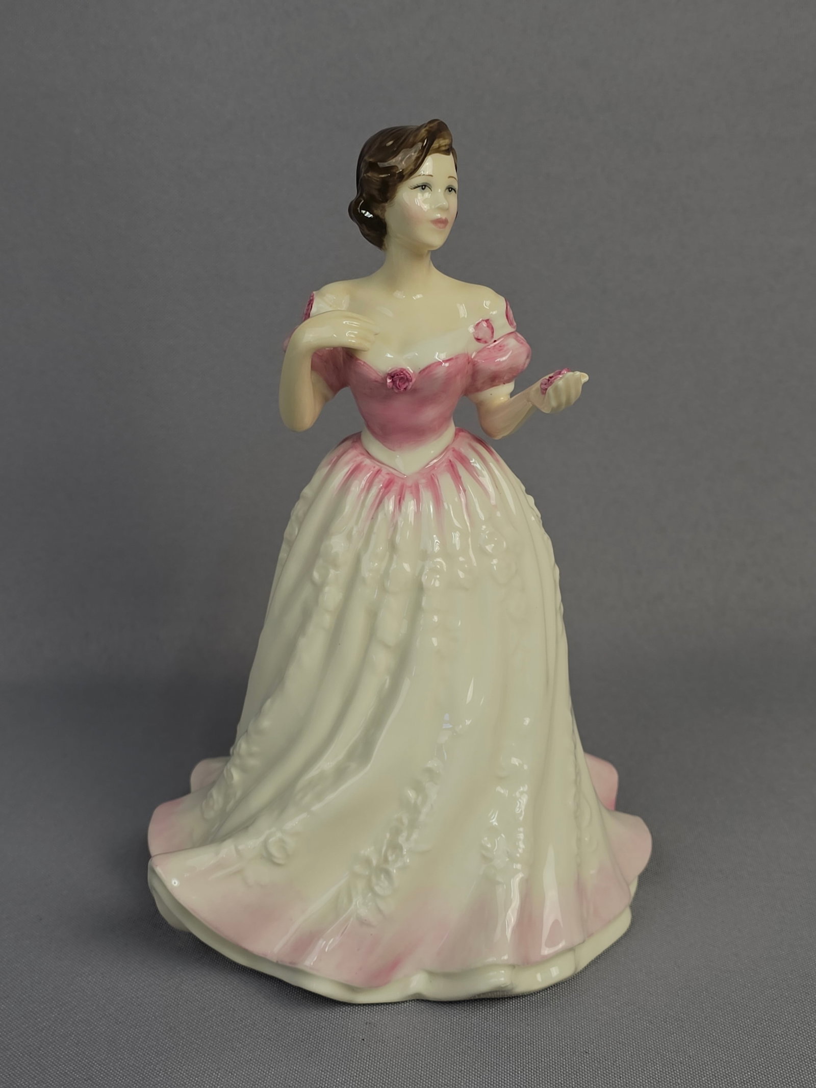 Royal Doulton 'Charity' HN 4243 Bone China Figurine, 2000: A Royal Doulton 'Charity' HN 4243 bone china figurine, modelled by Nada M. Pedley, dated 2000. The glazed figurine depicts a standing woman in an elegant, off-the-shoulder ball gown, primarily in shad