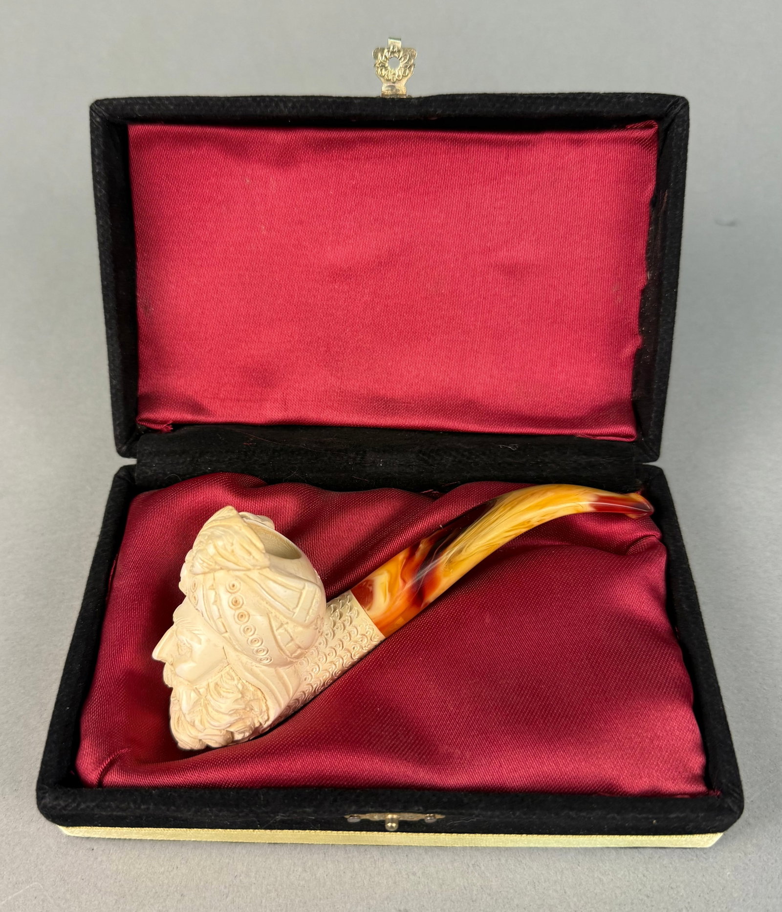 Carved Meerschaum Pipe Depicting an Ottoman Gentleman, with Case: An intricately carved meerschaum pipe, the bowl depicting a bearded man's head wearing a detailed turban, characteristic of an Orientalist or figural style, often referred to as an Ottoman gentleman o