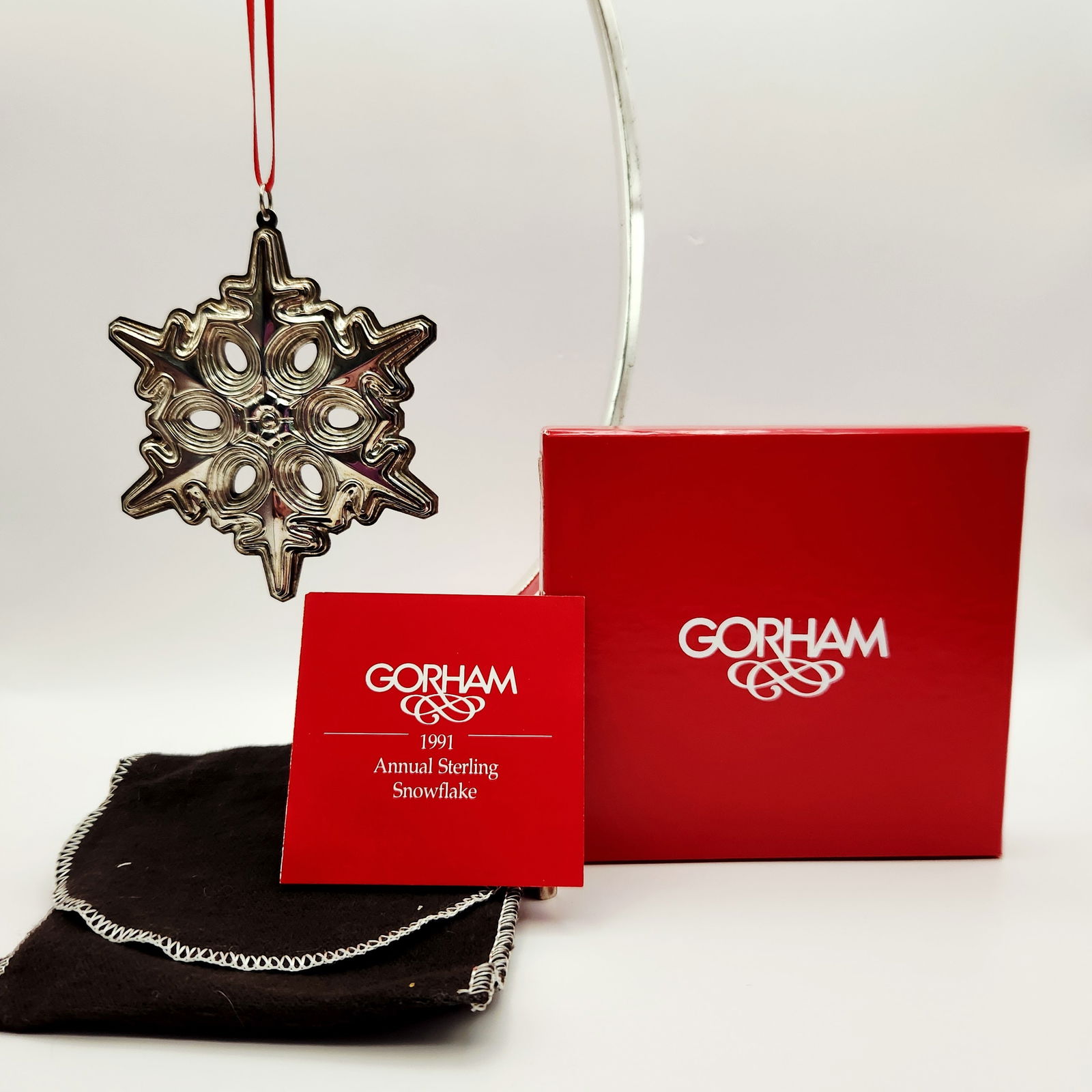 Gorham Sterling Silver 1991 Snowflake Christmas Ornament 22.8 Grams: A Gorham Sterling Silver 1991 Snowflake Christmas Ornament. Fashioned into a six-pointed snowflake design. The ornament is suspended by a red ribbon and is accompanied by its original rectangular red