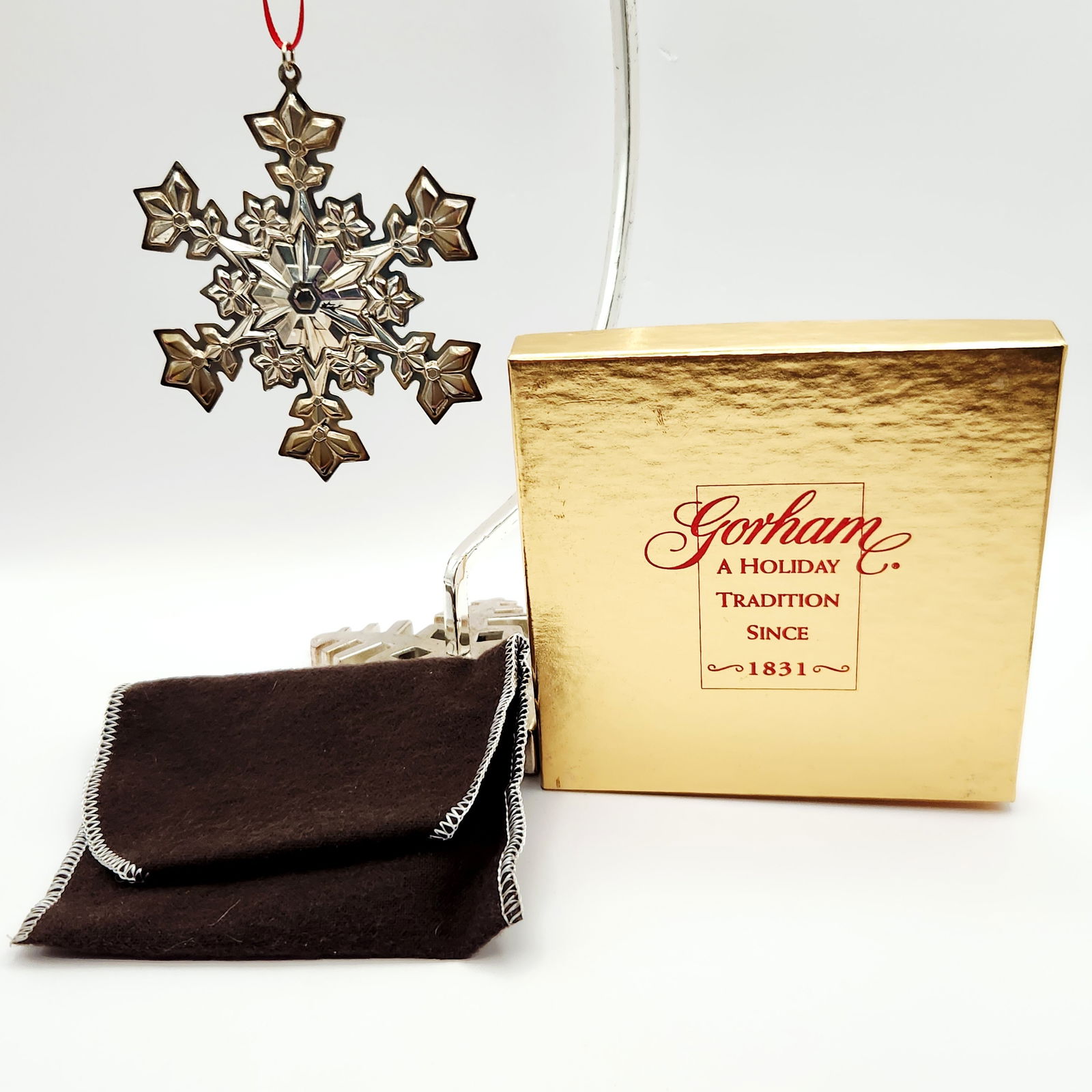 A Gorham Sterling Silver Snowflake Christmas Ornament 17.8 Grams: A Gorham Sterling Silver Snowflake Christmas Ornament from the year 2000. The ornament features a multi-faceted, reflective snowflake design. It is marked on the reverse with "© GORHAM STERL