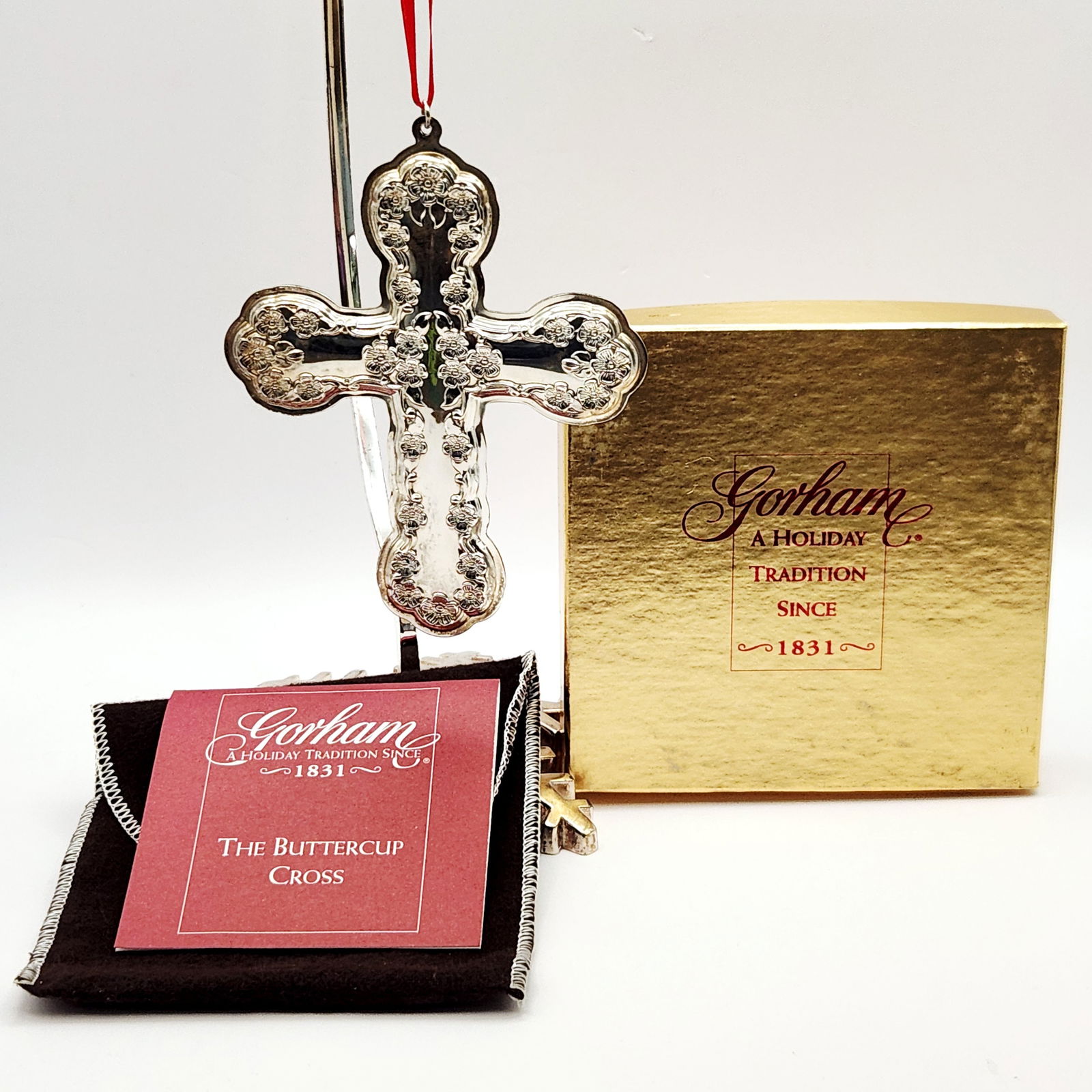 Gorham The Buttercup Cross Sterling Silver Christmas Ornament 29 Grams: A Gorham 'The Buttercup Cross' sterling silver Christmas ornament, dated 2000. The ornate cross features a dense, raised floral and foliate pattern on its front surface, with scalloped ends on the cro