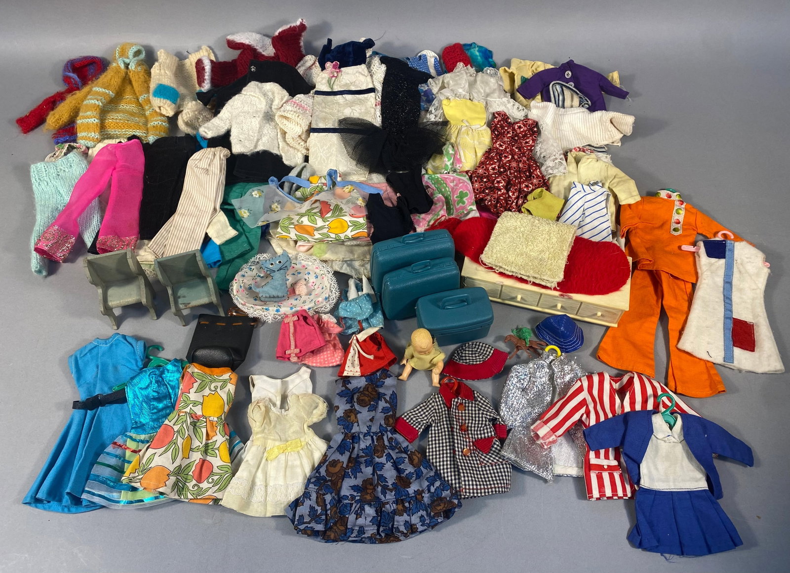 A Collection of Vintage Barbie Doll Clothing and Accessories, including a Susy Goose Dresser: A large collection of vintage Barbie doll clothing and accessories, indicative of a mid-to-late 20th-century period, likely 1960s-1970s. The clothing items include numerous dresses, tops, pants, sweat