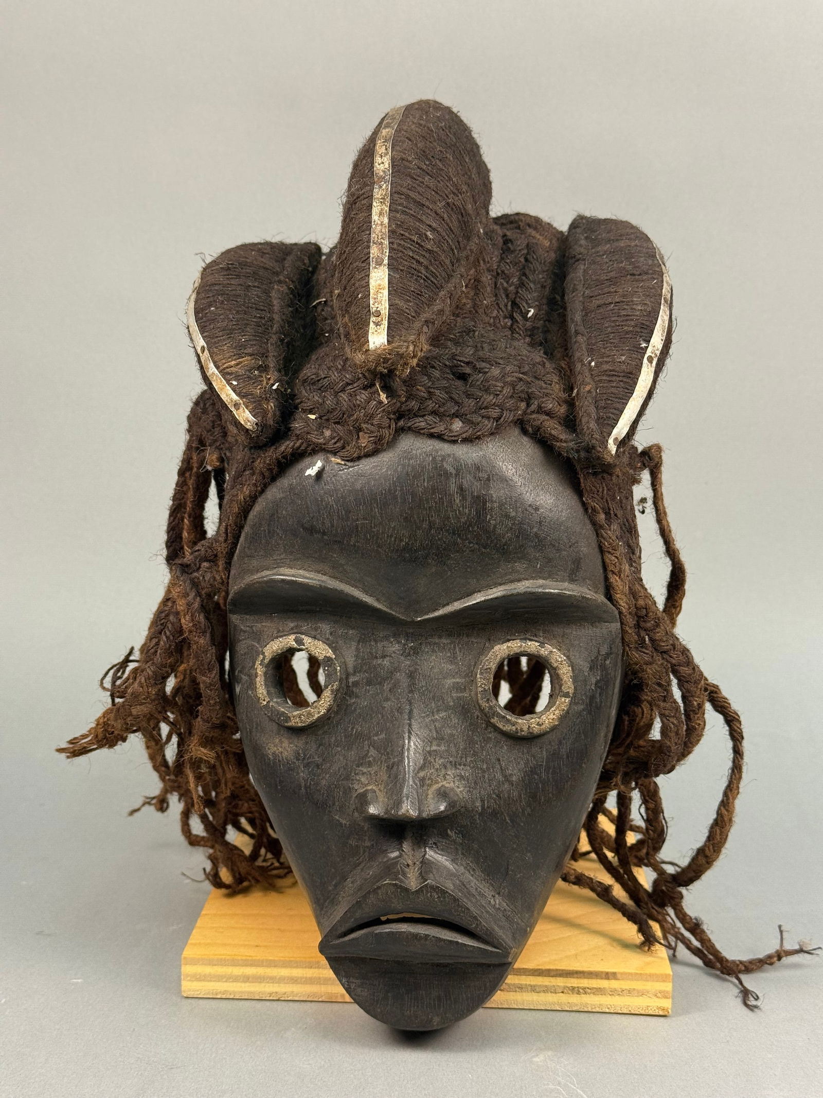 A West African Dan Gle Tribal Mask, Liberia: A West African Dan Gle tribal mask, likely from Liberia. Carved from dark wood with a rich, dark patina. The interior of the mask shows tool marks and a dark, worn finish. Length: 12 inches (30.
