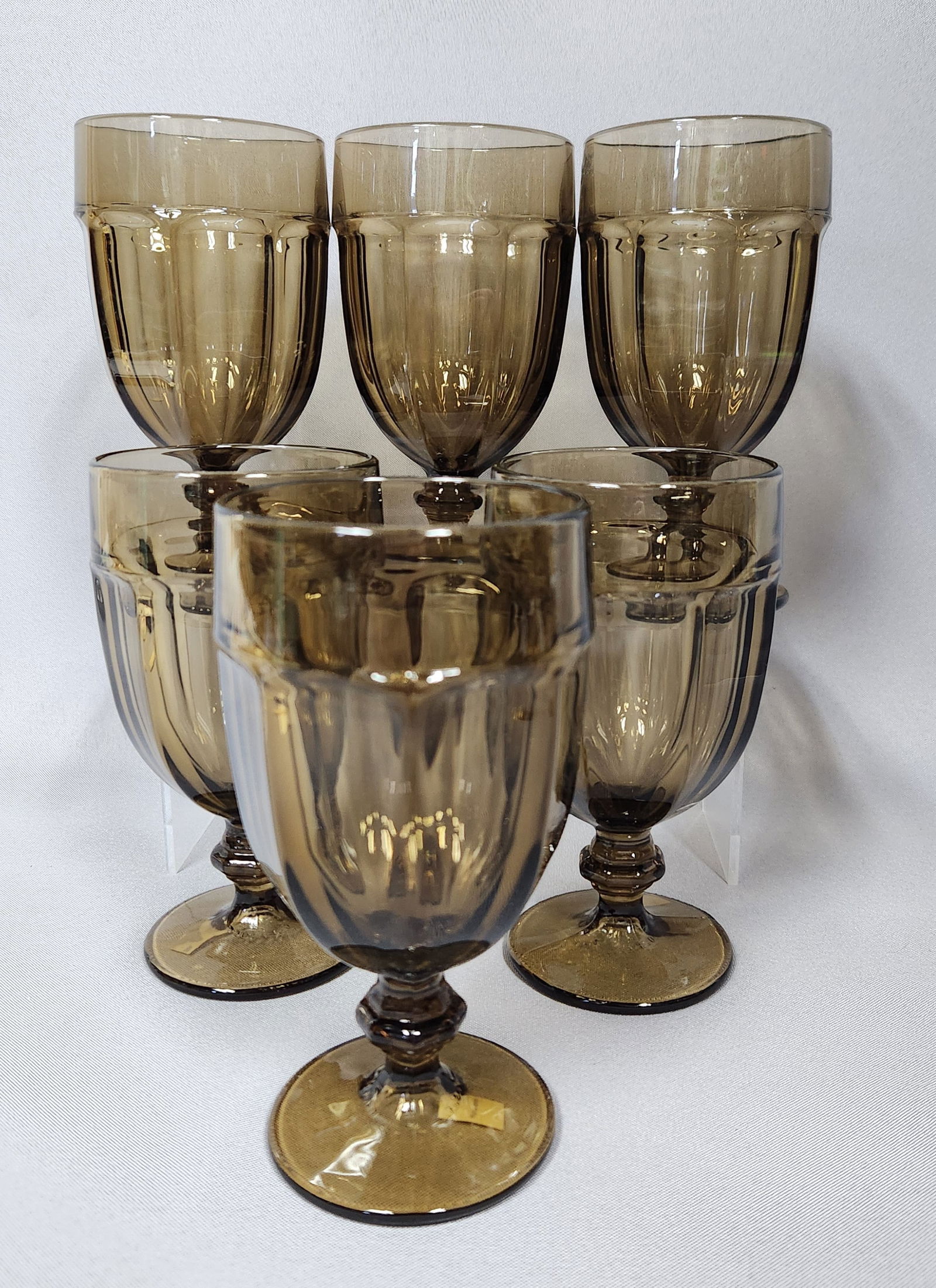 A Set of Six Sasaki 'Gibraltar Pattern' Amber-Brown Pressed Glass Goblets: A set of six Sasaki 'Gibraltar pattern' amber-brown pressed glass goblets. Each goblet features a faceted bowl with vertical fluting, a small knopped stem, and a round foot with a subtle ribbed unders