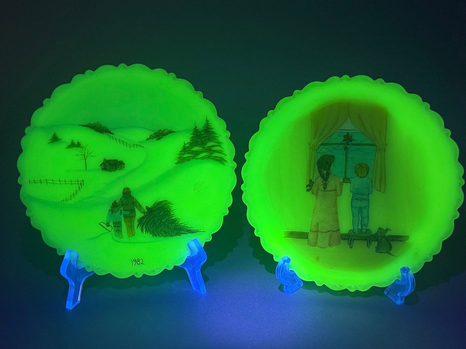 A Pair of Fenton Signed Hand-Painted Uranium Custard Satin Christmas Plates: A pair of Fenton signed hand-painted uranium custard satin Christmas plates. Each approximately 8 inches in diameter, crafted from opaque opalescent glass that exhibits a distinct bright green fluores
