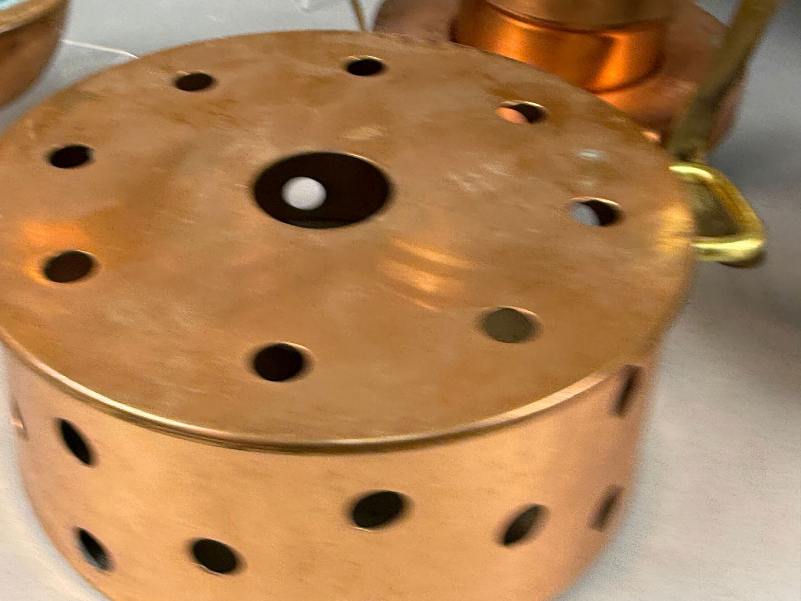 A Collection of Vintage Copper and Brass Chafing Dish and Fondue Set Components with Sterno Warmers: This collection features multiple copper and brass kitchenware items, primarily a chafing dish and fondue set components, indicative of a mid-20th century aesthetic. It comprises a large copper chafin