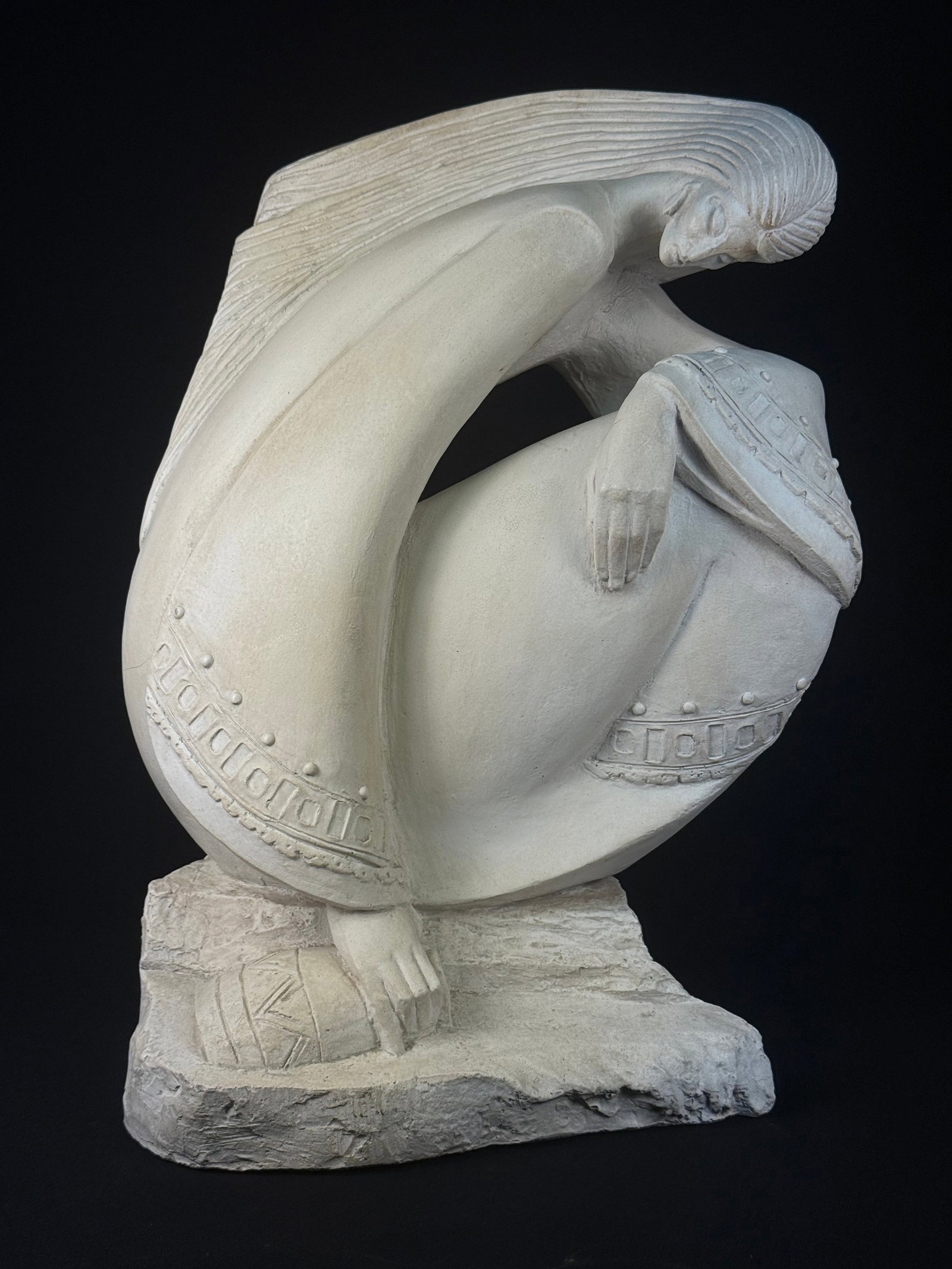 Austin Productions Acoma 'Rio De Vida' Sculpture, dated 1987: A 'Rio De Vida' sculpture by Austin Productions, dated 1987. This late 20th-century stylized figural sculpture depicts a seated or kneeling female figure with abstracted features, strongly ridged hair