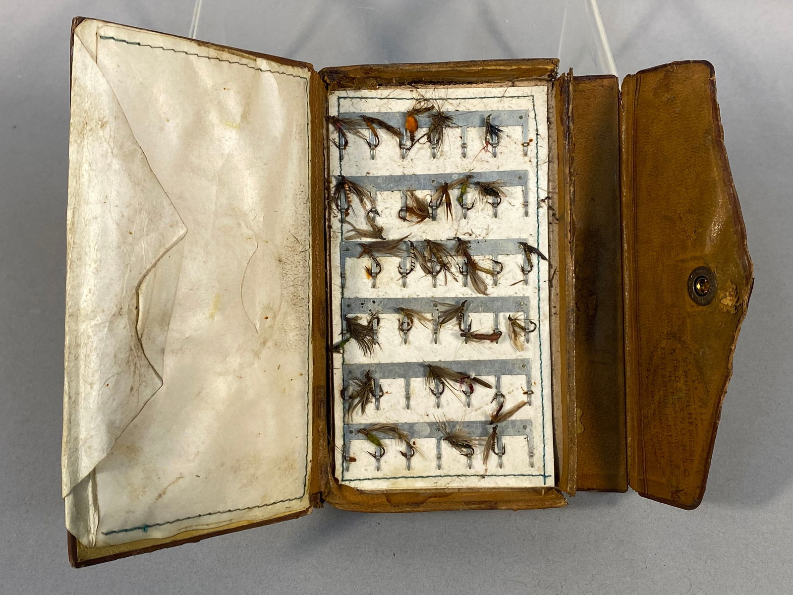 Antique T. Wil___ Practical Fly Dresser Kingsland, Herefordshire Leather Fly Fishing Wallet with: An antique fly fishing wallet or case, attributed to T. Wil___ Practical Fly Dresser of Kingsland, R.S.O., Herefordshire. The interior right flap bears a stamped inscription: "T. WIL___ PRACTICAL