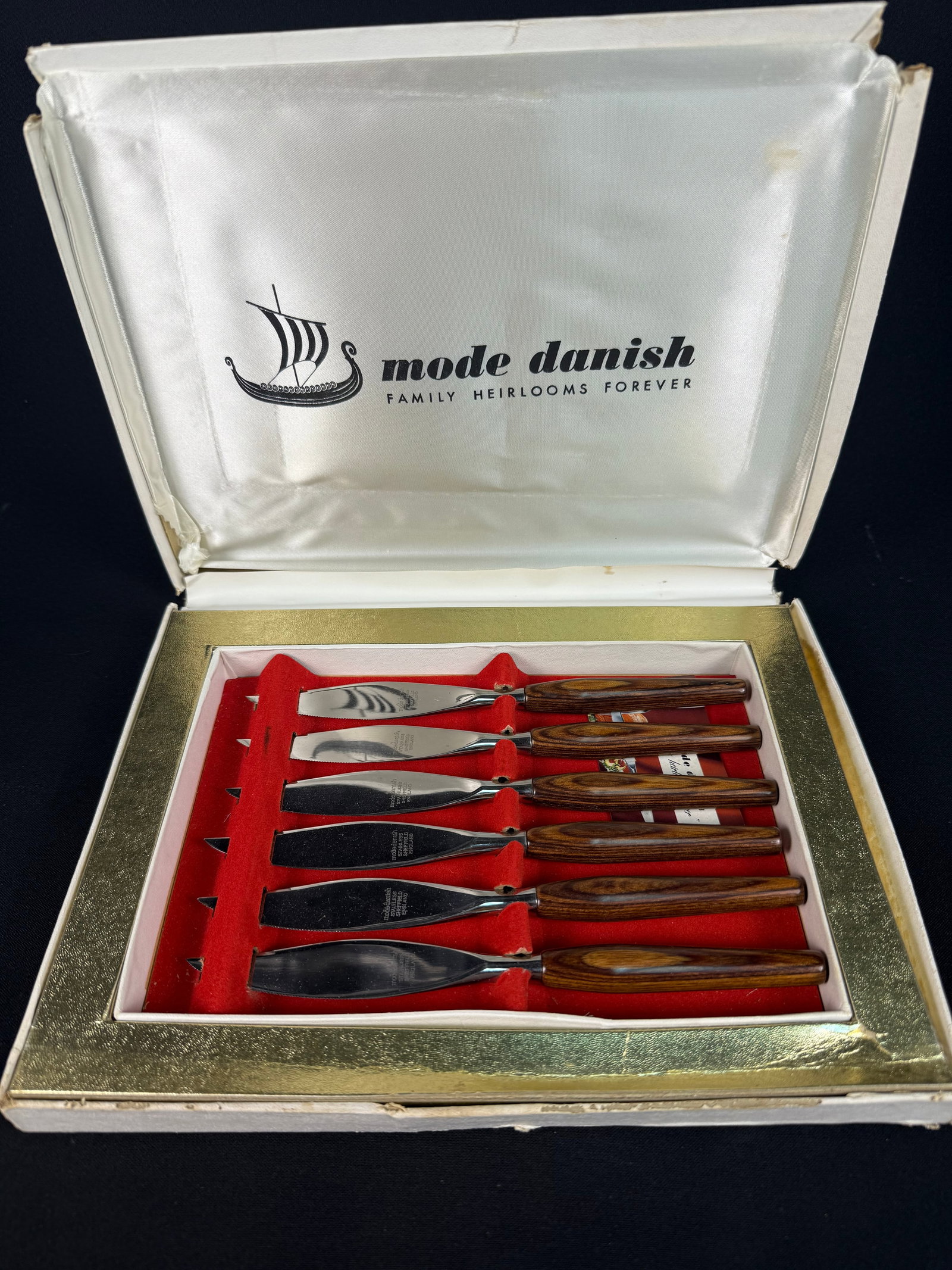 Mode Danish Family Heirlooms Forever Set of Six Steak Knives, Sheffield England: A set of six Mode Danish 'Family Heirlooms Forever' steak knives, crafted in Sheffield, England. Each knife features a polished stainless steel blade and a distinctively grained dark wood handle. The 