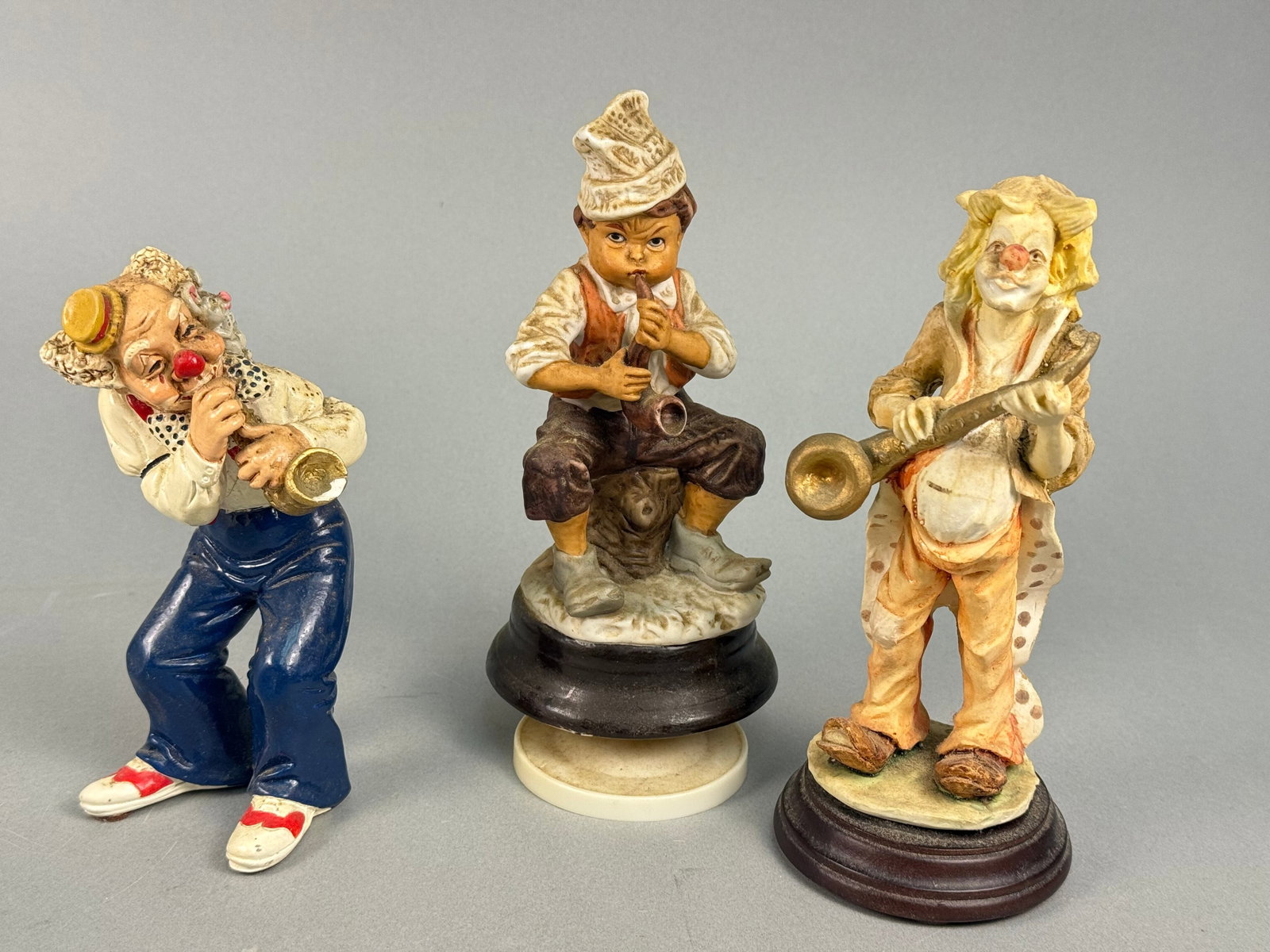 Three Pucci Hobo Clown Musical Figurines: Three Pucci Hobo Clown musical figurines, likely crafted from resin or a similar composite material, each depicting a musical performer in a whimsical, character-driven style with detailed clothing an