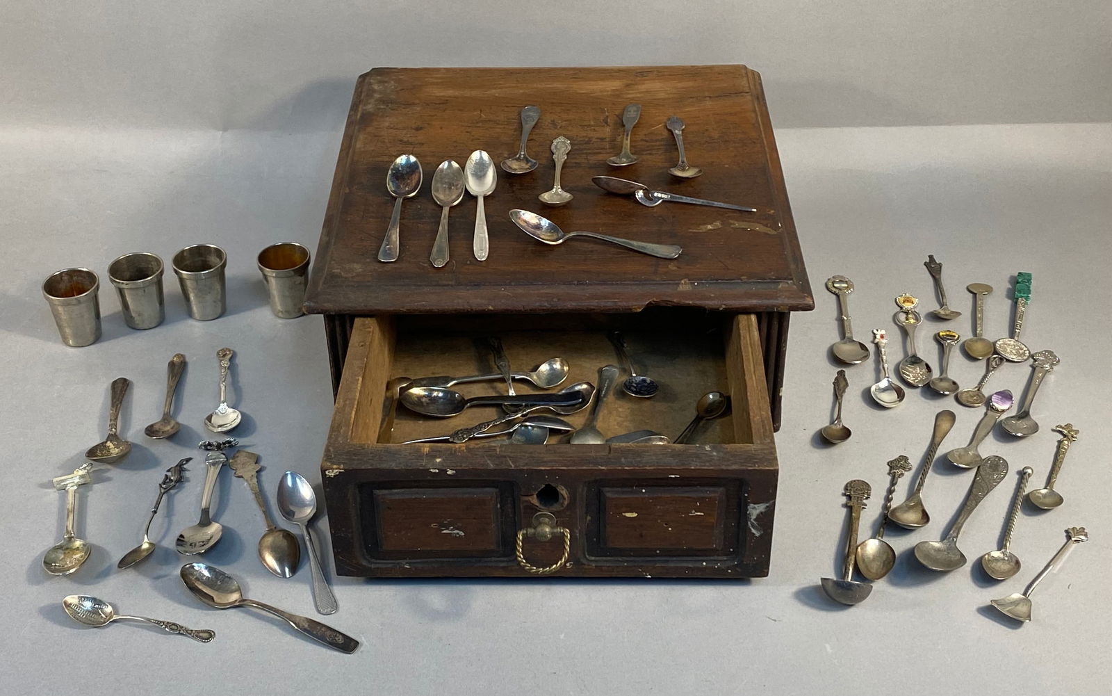 A Collection of Souvenir and Sterling Silver Spoons, Four Metal Cups, and a Wooden Storage Box (1 of 17)