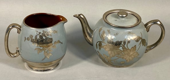 A Sadler Light Blue Glazed Creamer and Teapot with Metallic Floral Decoration, England