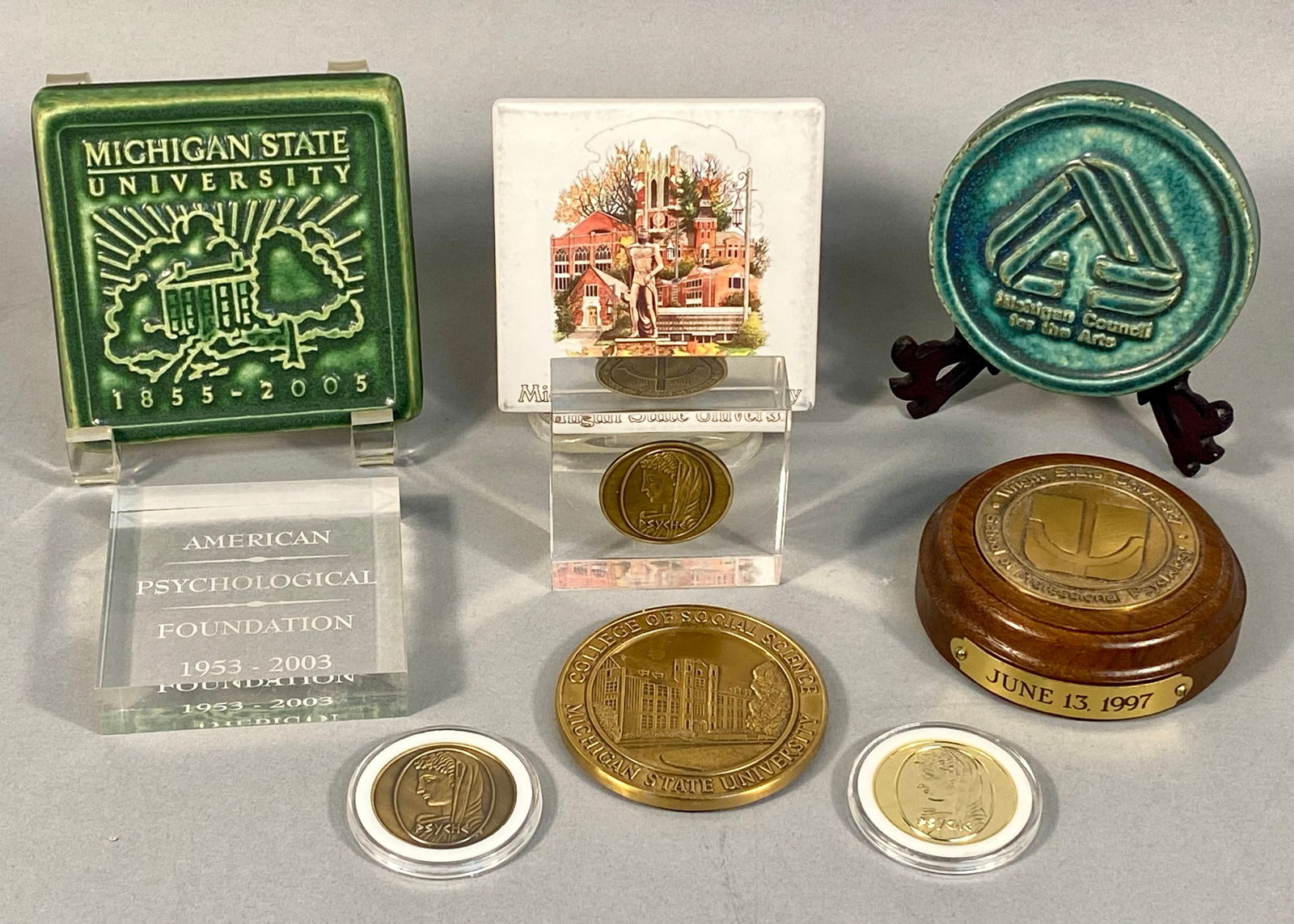 A Collection of Nine Late 20th and Early 21st Century Commemorative Items, Including Pewabic Tiles,: A collection of nine commemorative items, primarily from the late 20th and early 21st centuries. The group includes three glazed ceramic tiles: a 2004 green square Pewabic tile commemorating "Michigan