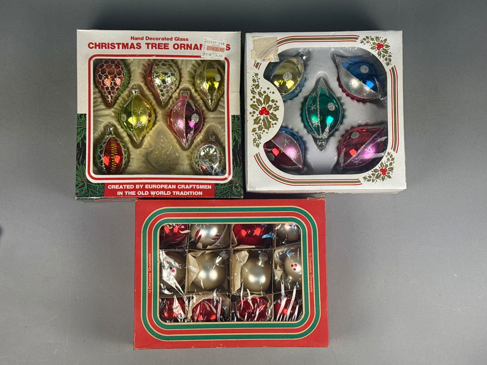 Three Boxes of Vintage Hand-Blown and Hand-Decorated Glass Christmas Ornaments: A collection of vintage hand-blown and hand-decorated glass Christmas tree ornaments, primarily crafted with glitter accents, presented in their original packaging. The lot comprises three distinct bo