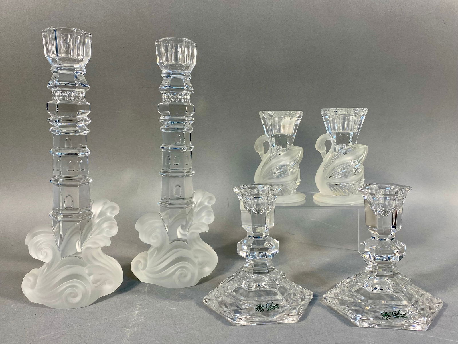 Three Pairs of Crystal Candlesticks, including Lenox Lighthouse: A collection of six clear and frosted glass candlesticks, presented as three distinct pairs, all appearing to be lead crystal. The first pair are Lenox 'Lighthouse' crystal candlesticks, featuring a c