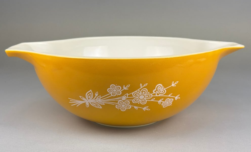 Pyrex 'Butterfly Gold' Cinderella Mixing Bowl, 444: A vintage Pyrex 'Butterfly Gold' Cinderella Mixing Bowl, model 444. This large mixing bowl is crafted from opaque white milk glass with a vibrant mustard yellow exterior finish and a contrasting white