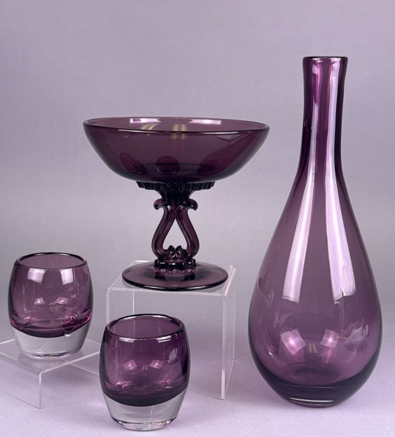 A Four-Piece Set of LSA International Amethyst-Ton: A four-piece set of amethyst-toned glassware by LSA International, handcrafted and mouthblown in Poland. The set comprises a tall, slender-necked vase with a bulbous base, a footed compote bowl featur