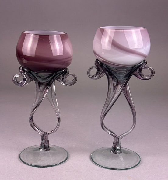 A Pair of Krosno Polish Hand Blown Amethyst Art Gl: A pair of Krosno Polish hand blown art glass goblets. Each piece features an opaque, rounded bowl with internal swirling patterns of purple, mauve, and white; one bowl is predominantly darker purple,